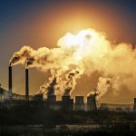 Factory smokestacks billowing smoke into air