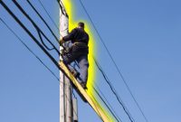 Man on ladder working on power lines